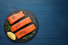 Fresh Raw Salmon, Slice Of Lemon And Spices On Blue Wooden Table, Top View. Space For Text