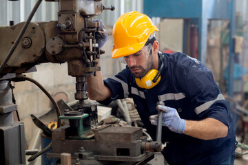 Wall Mural - Young caucasian engineer man operating lathe machine for preparing production at factory industrial, technician or labor maintenance machinery at workplace, metalworker working, industry concept.