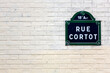 Traditional Paris plaque with the street name on white brick wall, France