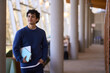 © Maria Vitkovska - Confident portrait of a thoughtful smiling young Hispanic male student visiting a modern library