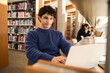 © Maria Vitkovska - Latin American male student using laptop, making researches on internet in modern innovation library
