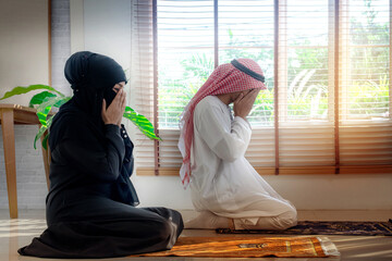Wall Mural - Muslim man and woman praying at home