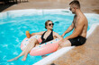 © omelnickiy - guy and a girl in bathing suits are relaxing, near the blue pool