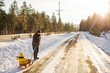 © Cavan Images - Retired, active Grandfather pulling his grandson on a wooden sled