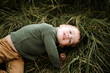 © Cavan Images - Little cute boy is lying on the green grass on a sunny day