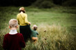 © Cavan Images - A trio of family walking from behind  in the meadow