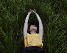 Young Woman Lying Down On A Green Grass.