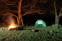 A Camp Site With Fire And Tent Lit Up