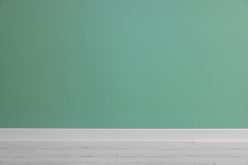 Poster - Beautiful light green wall and wooden floor in clean empty room