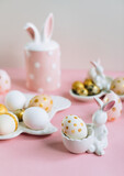 Fototapeta Storczyk - Golden glitter Easter eggs on plate in shape of rabbit on pink background