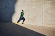 © baranq - Male runner sprinting during sunny afternoon in the city next to concrete wall. Healthy lifestyle concept