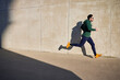 © baranq - Man running during sunny afternoon in the city next to concrete wall. Active lifestyle concept