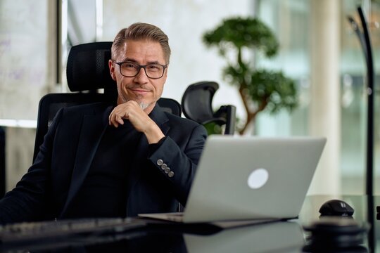 Fototapete -  - Business portrait - Businessman working with laptop computer sitting in meeting room in modern office. Happy middle aged, mid adult, mature age man smiling.