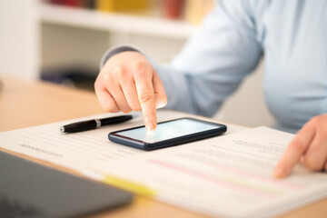 Close up of entrepreneur woman hands signing contract on smart phone with finger at home