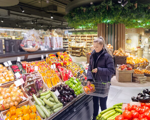 Wall Mural - Woman buying vegetables(pepper, chili pepper, eggplant, zucchini) at the market