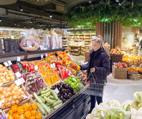 Wall Mural - Woman buying vegetables(pepper, chili pepper, eggplant, zucchini) at the market