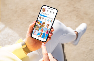 Wall Mural - woman holding phone in hand and viewing social media content