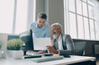 © gstockstudio - Two confident men doing some paperwork while spending time in the office together