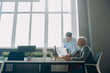 © gstockstudio - Two confident men going through documents while working in the office together