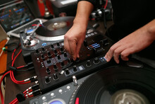 Hip Hop DJ Mixing Vinyl Records On Turn Table In Close Up. Professional Disc Jockey Plays Music Set With Sound Mixer And Turntables