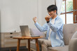 © Pichsakul - Business lifestyle, Businessman reading good news on laptop and raising arms with winner gesture