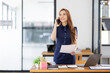 © David - Cheerful business Asian woman freelancer making telephone call share good news about project working in office workplace, business finance concept.
