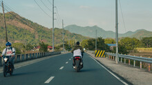 Nasugbu, Batangas, Philippines - A Motorcyle Cruises Through A 2 Lane Highway On The Way To Cavite. Mt. Pico De Loro In The Background.