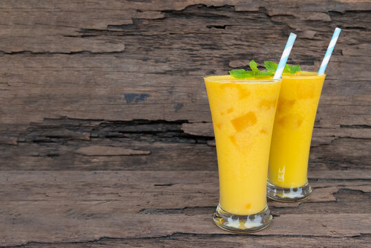 Fototapete - Mango juice fruit smoothies yogurt drink yellow healthy delicious taste in a glass slush for weight loss on wooden background.