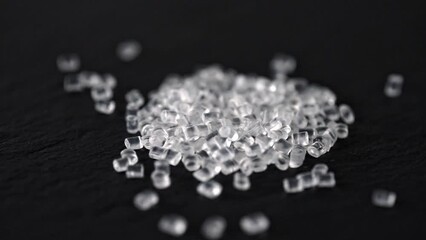 Wall Mural - Transparent Plastic granules. Polymer pellets on a black background.