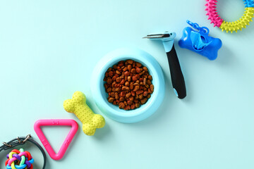 Dog feeding and grooming concept. Flat lay pet accessories on blue table.