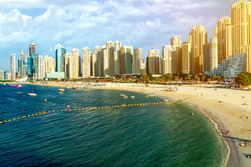 Wall Mural - The Dubai resort showcases a stunning modern architecal landscape with an expensive harbor filled with lavish boats and towering skyscrapers against the backdrop of a bright sun with clouds.