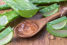 Dripping Juice From Sliced Pure Aloe Vera Leaf On Wooden Spoon. Sliced Aloe Vera Leaves With Transparent Gel Drops Closeup.
