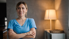 Smiling Female Nurse In Medical Scrubs. The Career Of Nursing Requires A Lot Of Compassion. Ortrait Of Female Nurse Inside The Modern Penthouse Apartment. Portrait Of A Home Caregiver Smiling