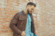 © Viorel Sima - casual man leaning on brick wall and arranging his jacket