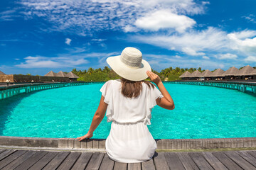 Wall Mural - Woman sitting on the wooden pier