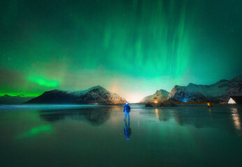 Wall Mural - northern lights and man on the beach at night. lofoten islands, norway. beautiful aurora borealis. p