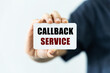 callback service text on blank business card being held by a woman's hand with blurred background. Business concept about callback service.