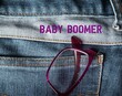 Reading glasses on jeans pocket with text BABY BOOMER , shortend from Baby boomers - demographic generation born following World War II 1946-1964, now mostly in retirement age