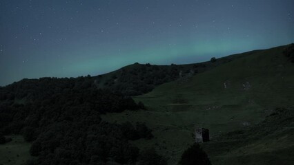 Wall Mural - Northern Lights are shining over the green hill at night. Time Lapse. 