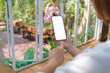 © Farknot Architect - Mockup image of a woman holding and using mobile phone with blank desktop screen in cafe