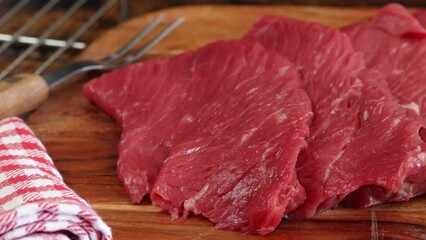 Sticker - plusieurs steaks de boeuf crus, en gros plan, sur une planche à découper