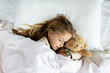 Candid lifestyle portrait of caucasian child eight years old in pajamas sleeping in bed at cozy home at morning