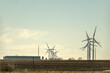© Cavan Images - Wind turbines rotating above farm field in the American Midwest
