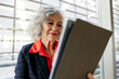 © Westend61 - Smiling mature businesswoman with gray hair using tablet PC