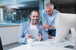 © Westend61 - Happy business colleagues sharing tablet PC at office