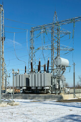 Wall Mural - A power transformer in a high-voltage electrical substation outdoors in winter.