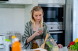 Young woman watching cooking tutorials video in kitchen