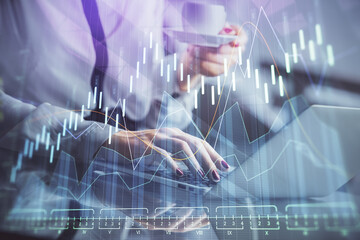 Poster - Double exposure of businesswoman hands typing on computer and financial graph hologram drawing. Stock market analysis concept.