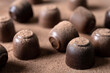 Chocolate bonbons and cocoa powder background
