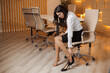 Tired young business woman secretary  sitting on chair and take off heel shoes